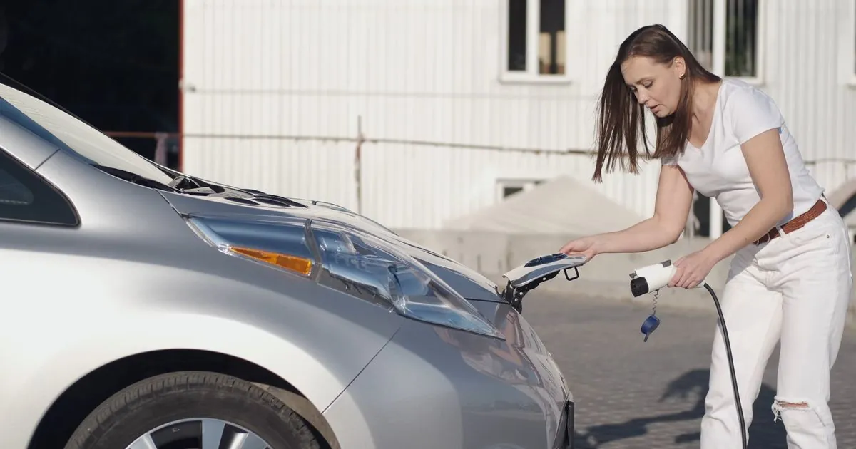 Vrouw steekt een Type 2-laadstekker in haar elektrische wagen